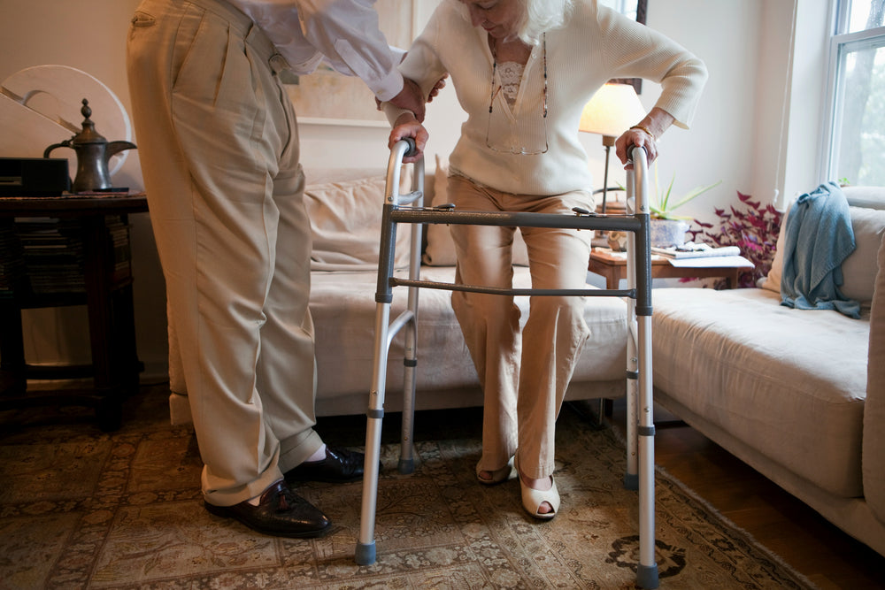 A 1st AB Med Supplies team member assisting a senior client using a walker